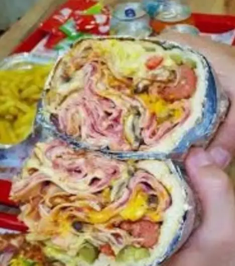 ساندویچ رول بسیار بزرگ و خاص فست فود گلها، شامل لایه‌های فراوان ژامبون، پنیر و سوسیس، تجربه طعم پیتزا و ساندویچ.