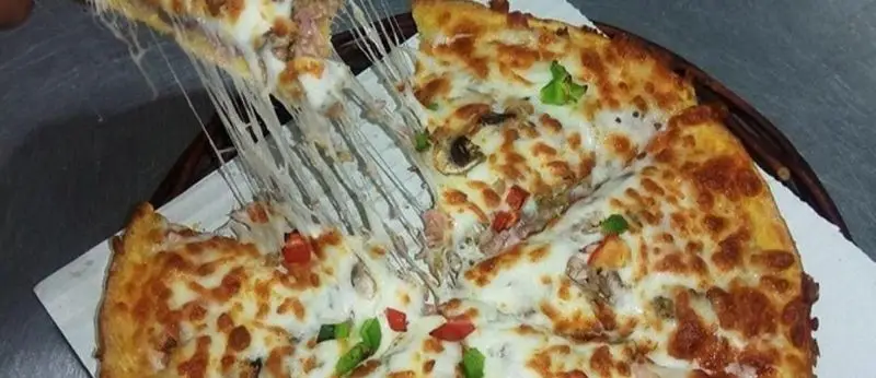 پیتزای داغ و خوشمزه فست فود گلها با پنیر کشدار، قارچ و فلفل دلمه‌ای، تصویری اشتهاآور برای مشتریان پیتزا و ساندویچ گلها.