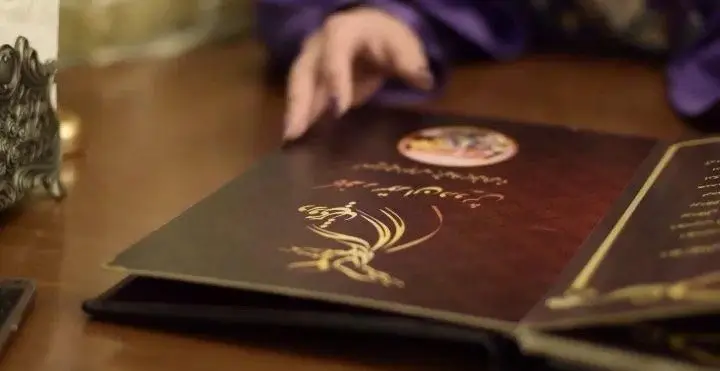 تصویری از مشتری که در کافه رستوران درویش منوی نفیس با طرح طلایی را باز می‌کند، آماده برای انتخاب و سفارش انواع غذا و نوشیدنی.