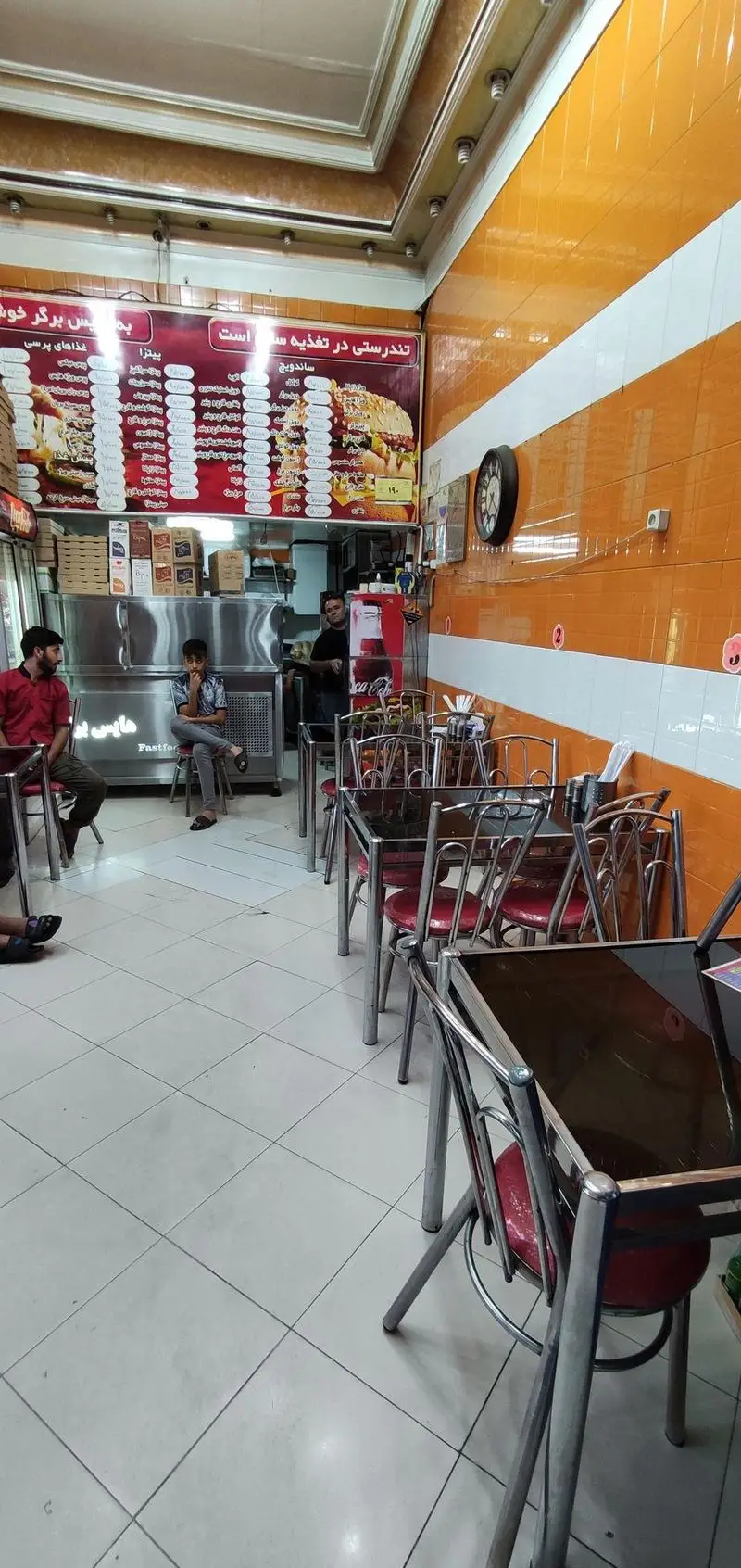 تصویری از داخل فست فود هایس برگر، نمایشگر منوی کامل پیتزا، ساندویچ و انواع برگر. محیطی تمیز و روشن برای مشتریان.