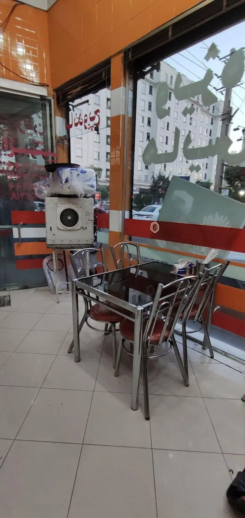 محیط داخلی فست فود هایس برگر: میز و صندلی‌های شیک، دکوراسیون مدرن نارنجی و محیطی جذاب برای تجربه بهترین برگر و ساندویچ.