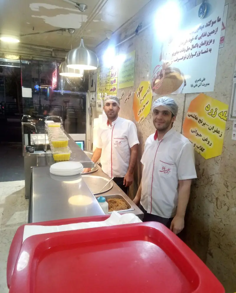 پرسنل آش علی بابا در آشپزخانه تمیز و بهداشتی، آماده سازی و سرو شله زرد و حلوا. بهترین آش و دسرهای سنتی با کیفیت.