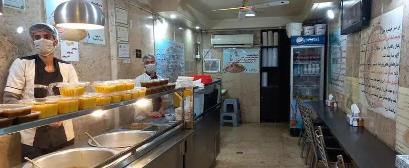 نمایی از فضای داخلی آش علی بابا، رستوران سنتی با محیطی تمیز و بهداشتی، نمایش ظروف آش و حلیم تازه آماده شده برای مشتریان، پرسنل مجرب و خوش‌رو.