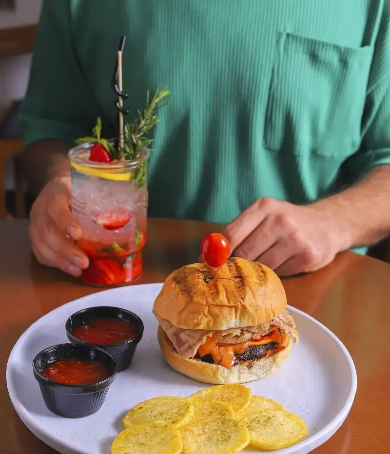 میز غذای کافه بینج با همبرگر گریل شده، سس‌های متنوع، چیپس سیب زمینی و موهیتو توت فرنگی. تجربه‌ای دلچسب.