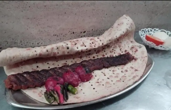 کباب کوبیده لذیذ کبابی ستاره قلهک با نان تازه و دورچین سبزیجات کبابی. انتخابی عالی برای یک وعده غذای اصیل ایرانی