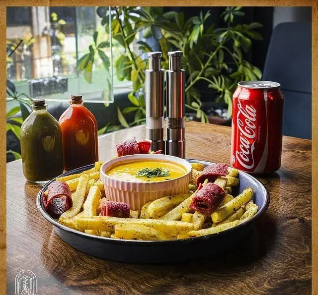 سیب زمینی سرخ کرده کافه آموره با سس پنیر مخصوص، سوجوک و نوشیدنی کوکا کولا، تجربه ای خوشمزه و هیجان‌انگیز برای مشتریان.