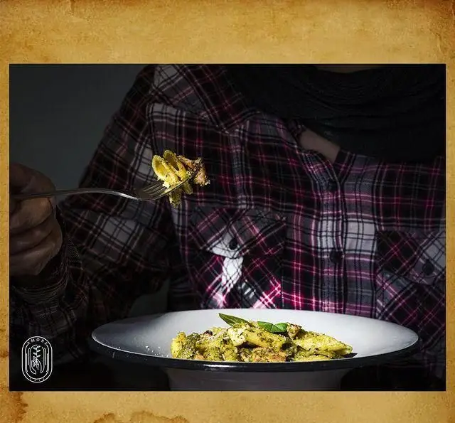 شام دلچسب در کافه آموره: پاستا پنه با سس پستوی خانگی و تکه‌های مرغ، آماده سرو. لحظه‌ای از تجربه دلپذیر غذا خوردن در کافه آموره.