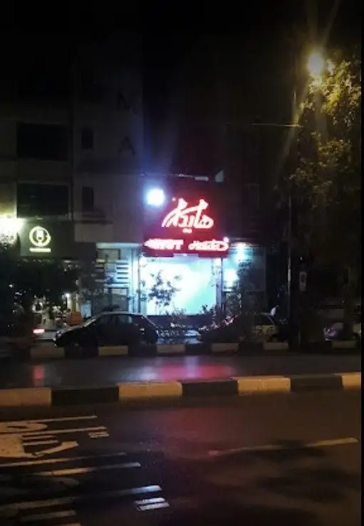 تصویری از نمای شبانه فست فود هایدا پیروزی با تابلوی نئون قرمز روشن. این رستوران محبوب در خیابان پیروزی واقع شده است.