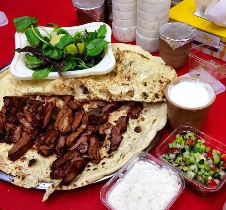 کباب شب زدگان: غذای کامل شامل گوشت لذیذ روی نان، سبزی تازه، ماست، سالاد و دوغ خنک. تجربه‌ای اصیل از کباب ایرانی.