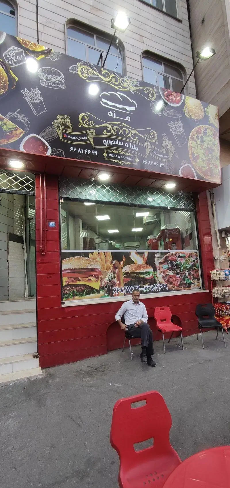 فست فود مزه: تابلوی بزرگ پیتزا، ساندویچ، برگر و سیب‌زمینی سرخ‌کرده. نمای مغازه با رنگ قرمز و پنجره‌های شیشه‌ای. مشتری و صندلی‌ها.