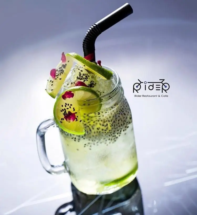 نوشیدنی خنک و تازه از کافی شاپ رایدر شامل دانه چیا، لیمو ترش و تزئین گلبرگ‌های زیبا، انتخابی ایده‌آل برای تابستان.