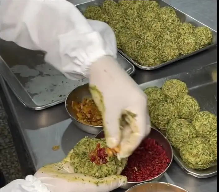 تهیه کوفته‌های اصیل و خوش‌طعم در آشپزخانه کترینگ ارغوان؛ پر کردن با مواد میانی شامل زرشک و مغزها برای سفارشات غذای خانگی.