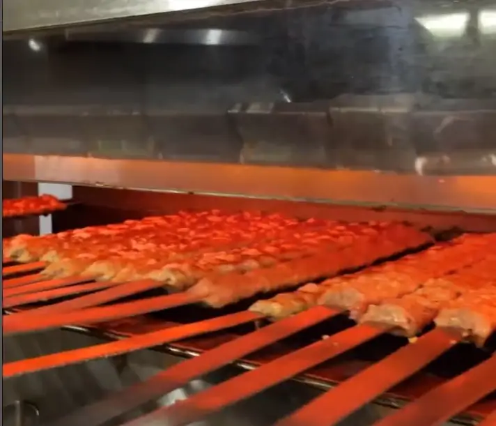 کباب کوبیده لذیذ در حال پخت روی گریل حرارتی در کترینگ ارغوان؛ طعم بی‌نظیر غذای ایرانی با مواد اولیه تازه و کیفیت برتر.