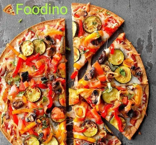 پیتزا سبزیجات تازه و خوشمزه فودینو با تاپینگ‌های رنگارنگ کدو، فلفل دلمه‌ای، قارچ و پنیر کش‌دار، آماده سرو در فست فود فودینو.