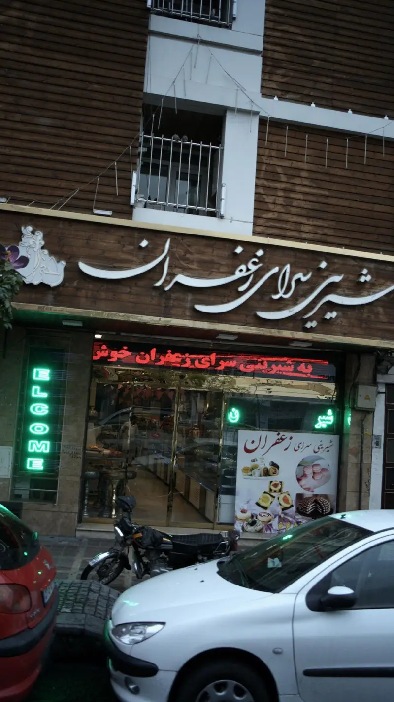 نمای خارجی شیرینی سرای زعفران، قنادی و فروشگاه شیرینی و دسر ایرانی با تابلو برجسته و ویترین محصولات.