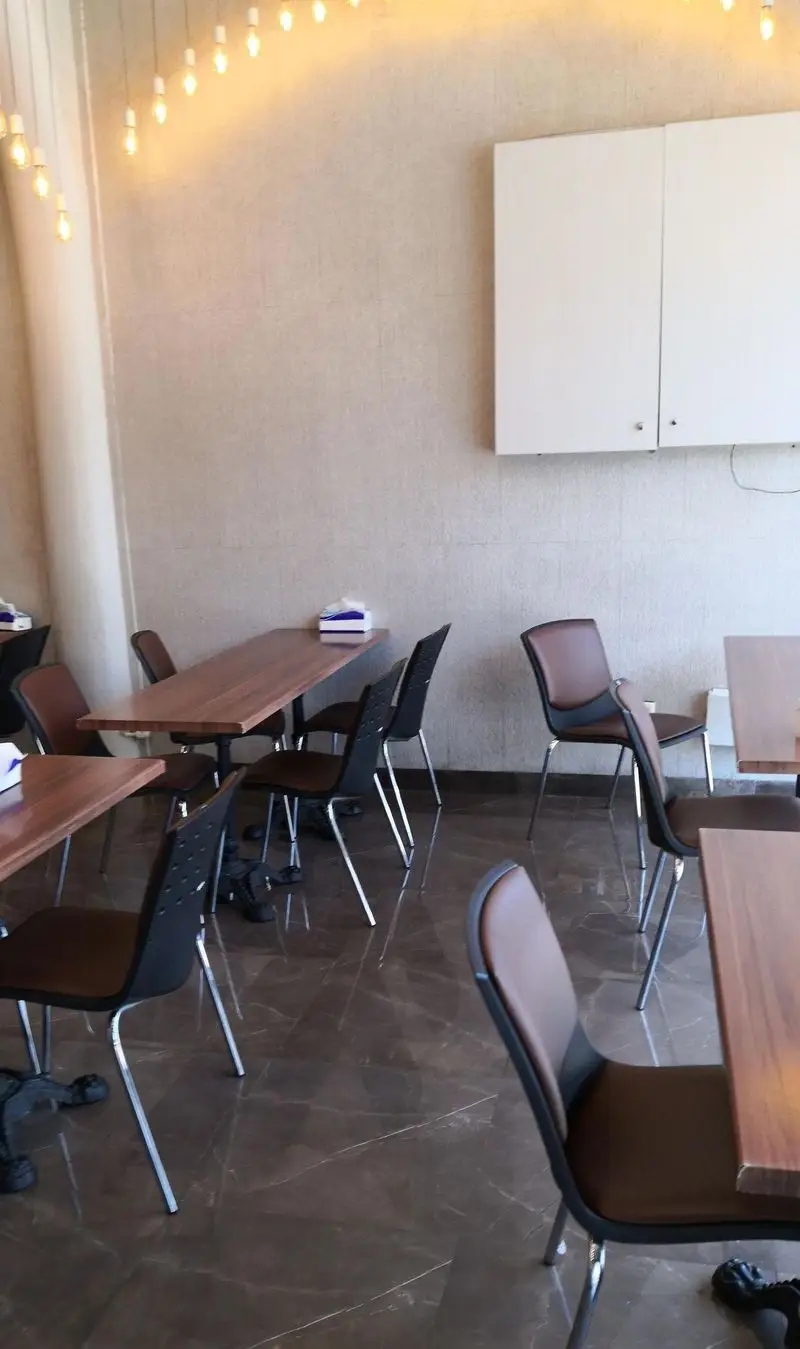 تصویری از محیط شیک و مدرن کافه رستوران سوپ چی با میزهای چوبی، صندلی‌های راحت و نورپردازی گرم برای تجربه دلپذیر.