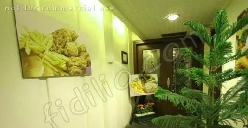 تصویری از دکوراسیون داخلی رستوران گریل ۴۵۸: راهروی مزین به تابلوهای مرغ سوخاری، سیب زمینی سرخ کرده و گیاهان سبز.