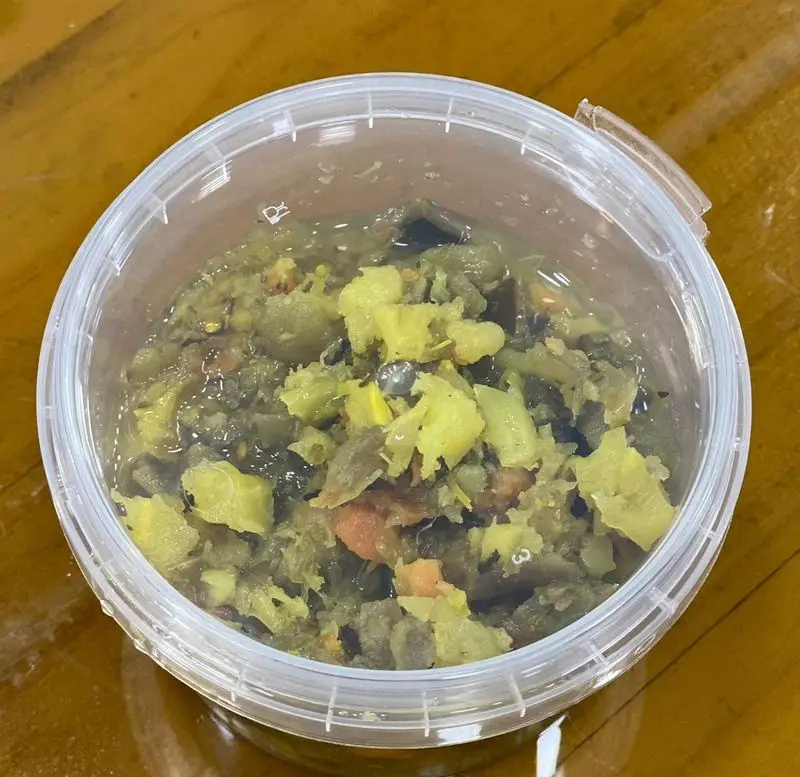 مخلوط غذای رژیمی رستوران برکت، درون ظرف پلاستیکی شفاف، حاوی سبزیجات خرد شده و تکه‌های زرد، با گلوله فلزی. غذای ایرانی فرنگی سالم.