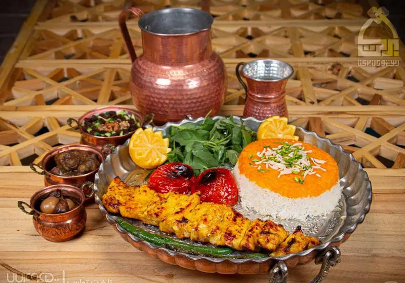 بشقاب سنتی مسی غذای اصیل و لذیذ ایرانی شامل جوجه کباب، برنج زعفرانی، گوجه کبابی با مخلفات متنوع در رستوران برکت