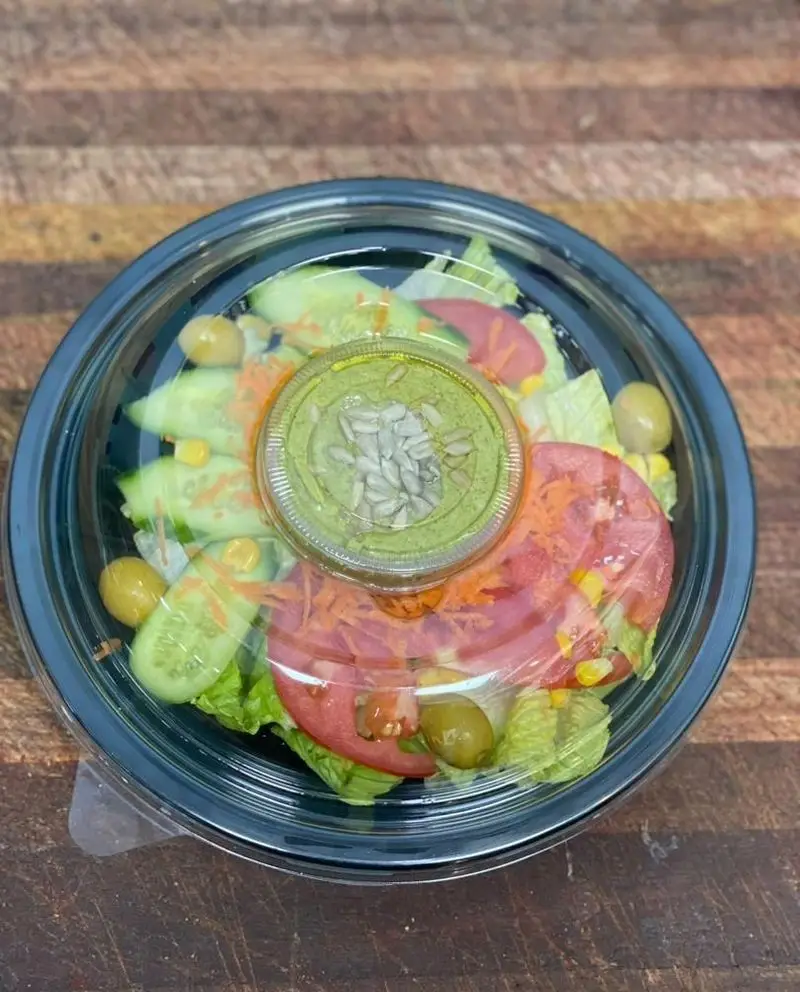 سالاد رژیمی و فرنگی تازه رستوران برکت، شامل کاهو، خیار، گوجه، هویج، ذرت و زیتون، آماده سرو در ظرف مخصوص با سس.