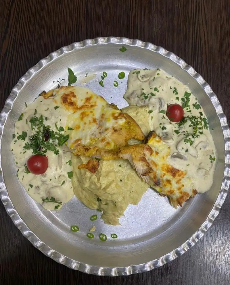 بشقاب چیکن گراتن جذاب رستوران برکت، شامل مرغ با پنیر، سس قارچ، پوره، غذای فرنگی و رژیمی برای سلامتی و لذت