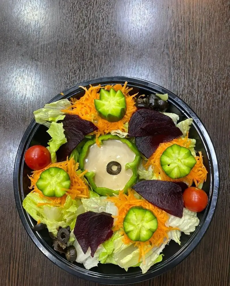 سالاد رژیمی و تازه رستوران برکت، ترکیبی از سبزیجات متنوع کاهو، هویج، چغندر، خیار و گوجه‌فرنگی با سس در ظرف مشکی