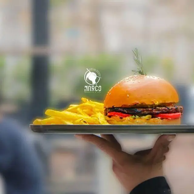 برگر لذیذ و سیب‌زمینی سرخ‌کرده طلایی سرو شده بر روی سینی، نمادی از کیفیت در کافه رستوران ایتالیایی نارکو.