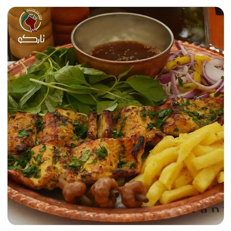 جوجه کباب طلایی کافه رستوران نارکو با سبزیجات تازه، سیب زمینی سرخ کرده و سس خوش‌طعم در بشقاب مسی.