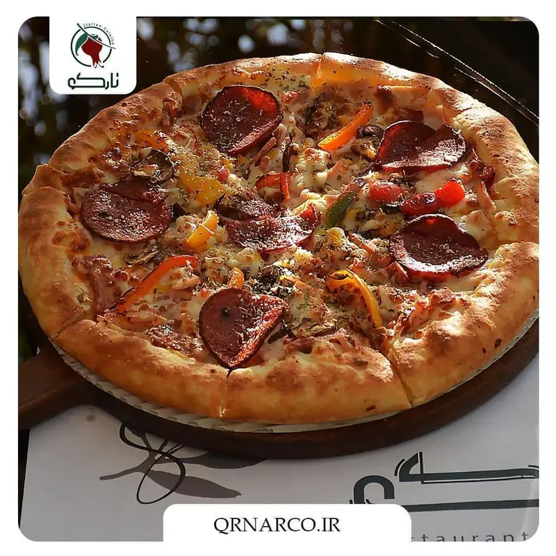 تصویری جذاب از پیتزا پپرونی با فلفل دلمه و پنیر فراوان در کافه رستوران نارکو، یک غذای ایتالیایی فوق العاده و دلپذیر.