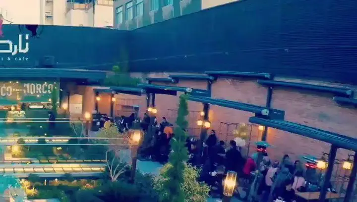 فضای زیبای شبانه کافه رستوران نارکو، با نورپردازی دلنشین و مشتریان در حال لذت بردن از محیط باز و منوی متنوع.