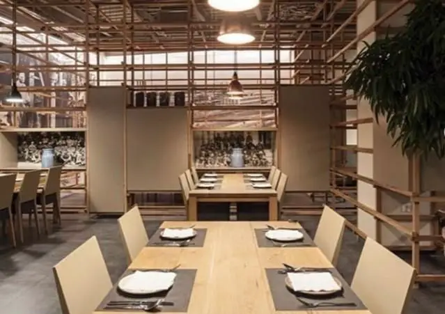 فضای دنج و مدرن کافی شاپ محفل با طراحی داخلی چوبی خاص، میزهای غذاخوری منظم و نورپردازی گرم برای یک دورهمی دوستانه.