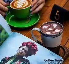 زمان قهوه در کافی شاپ شاهو: دو فنجان قهوه با لاته آرت زیبا، کاپوچینو و موکا، همراه با مطالعه مجله و لذت بردن از لحظات آرام. Shahou Cafe.