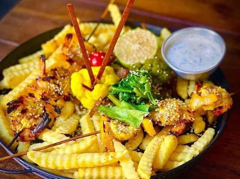 تصویری از بشقاب کامل و خوشمزه میگو کبابی با سیب زمینی سرخ کرده، کلم بروکلی، اسفناج، لیمو و سس در کافه رستوران مازو