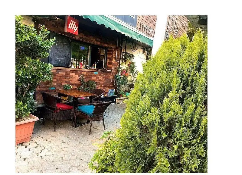 فضای باز دلنشین کافه رستوران مازو با میز و صندلی‌های حصیری و دکور آجری، محیطی آرامش‌بخش برای مشتریان.