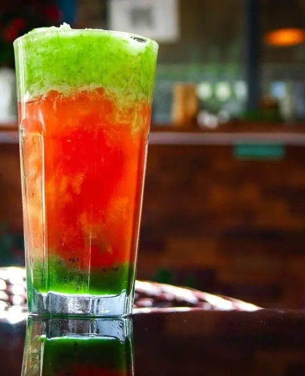 نوشیدنی لایه ای چشم نواز با ترکیب رنگ سبز و قرمز در لیوان، ارائه شده در کافه رستوران مازو. نوشیدنی خنک و تازه.