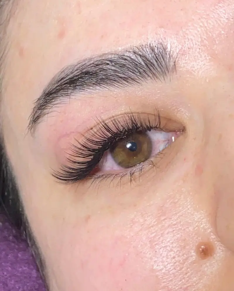 تصویری از چشم با اکستنشن مژه والیوم پرپشت و ابروهای طبیعی لیفت شده و مرتب، کاری از سالن زیبایی نینوش برای نگاهی گیرا.