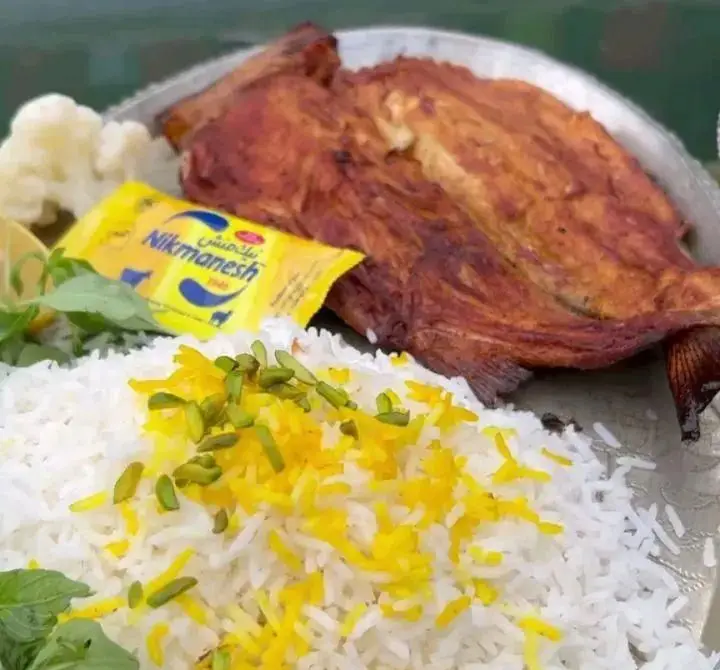 ماهی سرخ شده با پلو زعفرانی، پسته و کره در باغ رستوران سایدا شهران، غذای ایرانی اصیل و دلچسب.