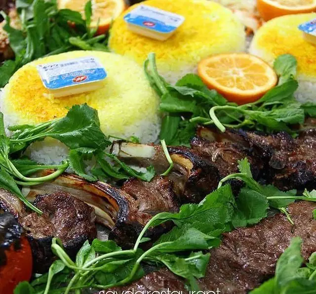 سرو انواع کباب از جمله شیشلیک با برنج زعفرانی، کره، سبزی تازه و پرتقال در باغ رستوران سایدا شهران. غذای اصیل ایرانی