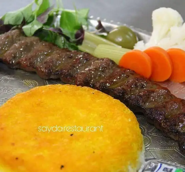 کباب کوبیده لذیذ باغ رستوران سایدا شهران با ته دیگ طلایی و دورچین سبزیجات تازه، بهترین غذای ایرانی برای ناهار و شام.