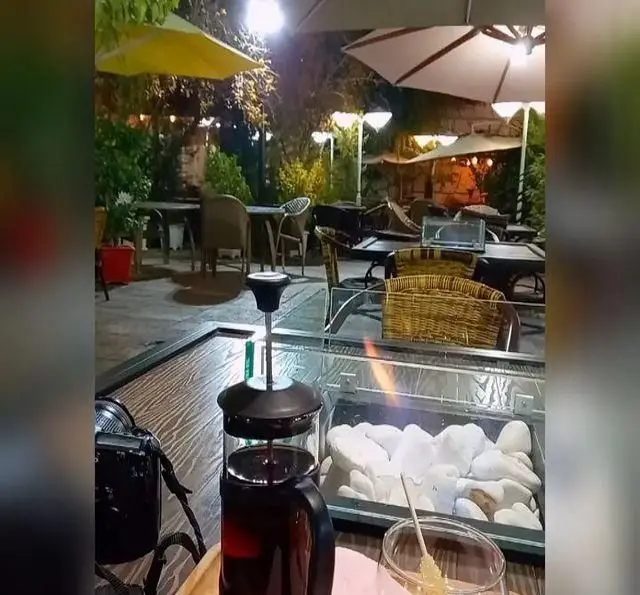 باغ رستوران سایدا شهران، فضای باز دلنشین و دنج در شب با نورپردازی زیبا، مناسب دورهمی و لذت نوشیدنی گرم.