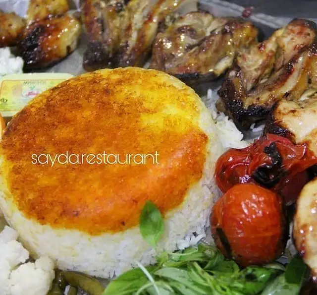 چلو کباب مرغ لذیذ با ته دیگ زعفرانی طلایی و گوجه کبابی، تجربه‌ای بی‌نظیر از غذای ایرانی در باغ رستوران سایدا شهران.