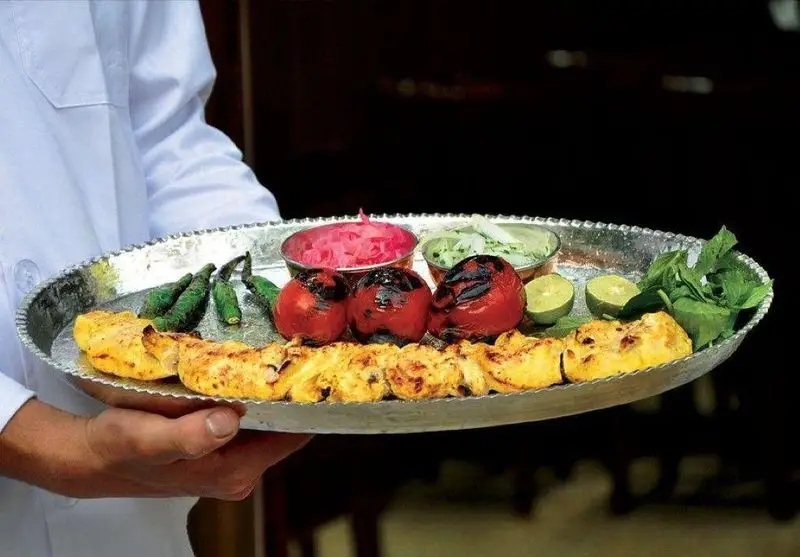 سینی زیبای جوجه کباب (یا ماهی کباب) همراه با گوجه و فلفل کبابی، پیاز ترشی، سس و سبزیجات تازه در کبابی سلطانی شعبه ۱.