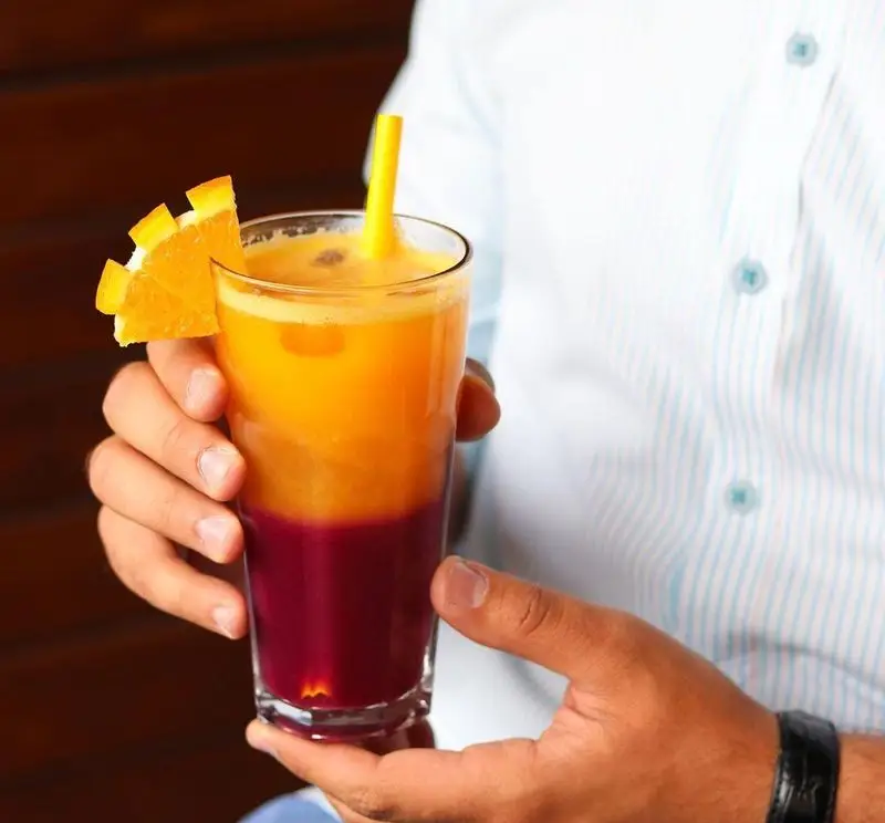 آبمیوه طبیعی و لایه ای خیره‌کننده کافه ویونا با رنگ‌های زنده پرتقال و میوه‌های قرمز، یک انتخاب عالی برای تجربه تازگی و طراوت.