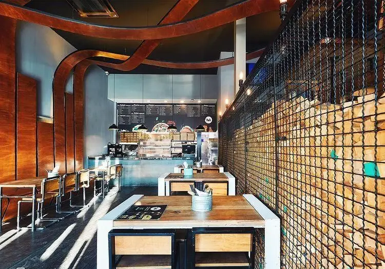 تصویری از فضای داخلی فست فود باروژ، با طراحی مدرن و دلنشین، میز و صندلی‌های چوبی، پیشخوان آماده سرویس و دکوراسیون خاص.