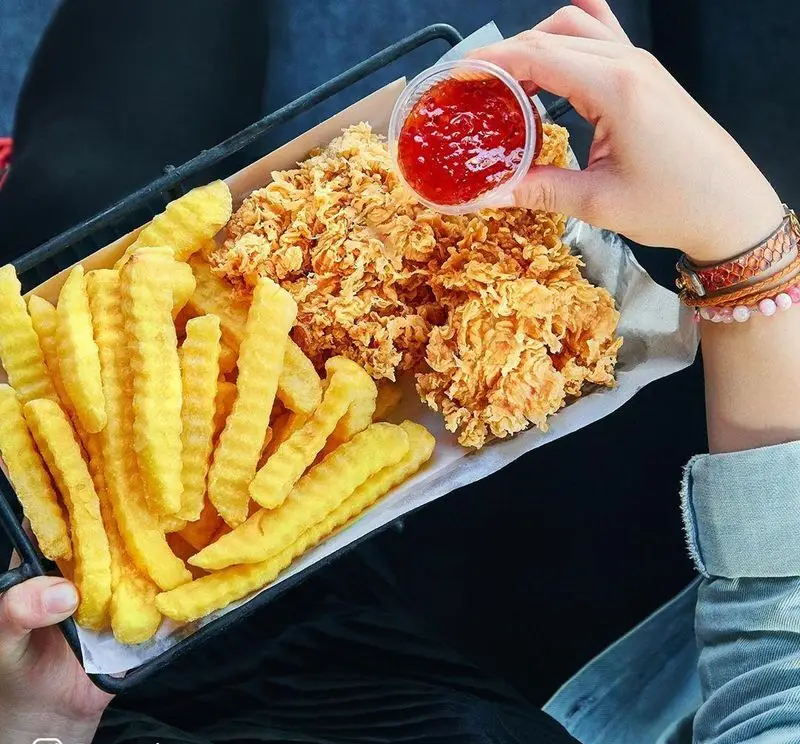 فست فود باروژ: سینی غذای کامل با سیب زمینی سرخ کرده موج دار و مرغ سوخاری ترد، همراه با سس قرمز خوش طعم برای تجربه‌ای لذت‌بخش.