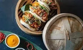 غذاهای خاص و لذیذ رستوران کره ای سُوان: باو بونزهای گوشت و سبزیجات تازه، سرو شده در سبد بخارپز بامبو سنتی. غذای کره ای عالی.