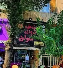 نمای بیرونی رستوران کُره ای سُوان با تابلوی صورتی و ورودی دنج و پردرخت. بهترین غذای کُره ای در محیطی دلنشین.