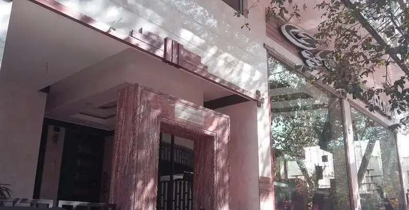 تصویری از درب ورودی پیتزا ماچی با طراحی شیک و سنگ‌کاری خاص، نشان‌دهنده فضای دلپذیر این رستوران فست فود محبوب.