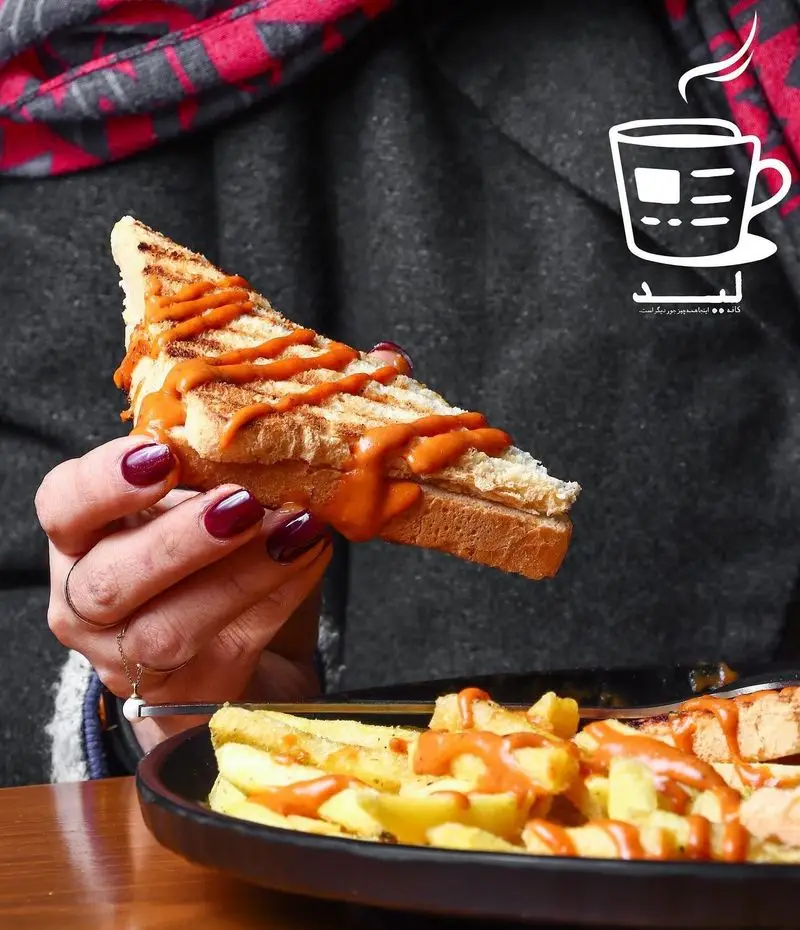 ساندویچ تست طلایی با سس جذاب و سیب‌زمینی سرخ‌کرده در کافه لید. لذت طعم‌های خاص و منحصربه‌فرد را در فضای دلنشین کافه لید تجربه کنید.