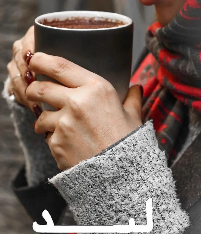 دستانی با لاک قرمز، فنجان قهوه داغ یا شکلات را در کافه لید به آرامی گرفته‌اند؛ تجربه لحظات دنج و دلنشین در هوای سرد.